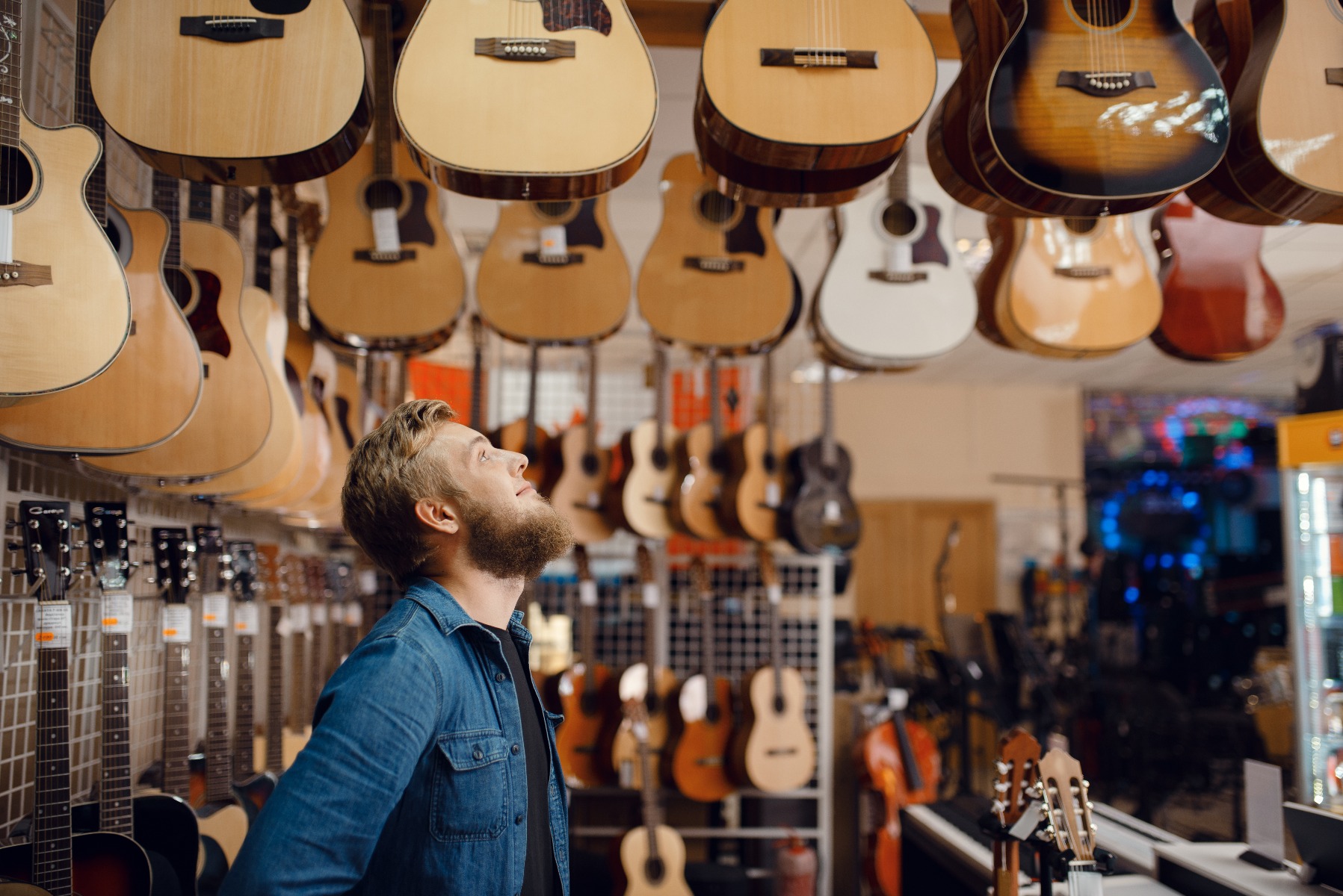 Ein Mann sucht sich eine Gitarre aus